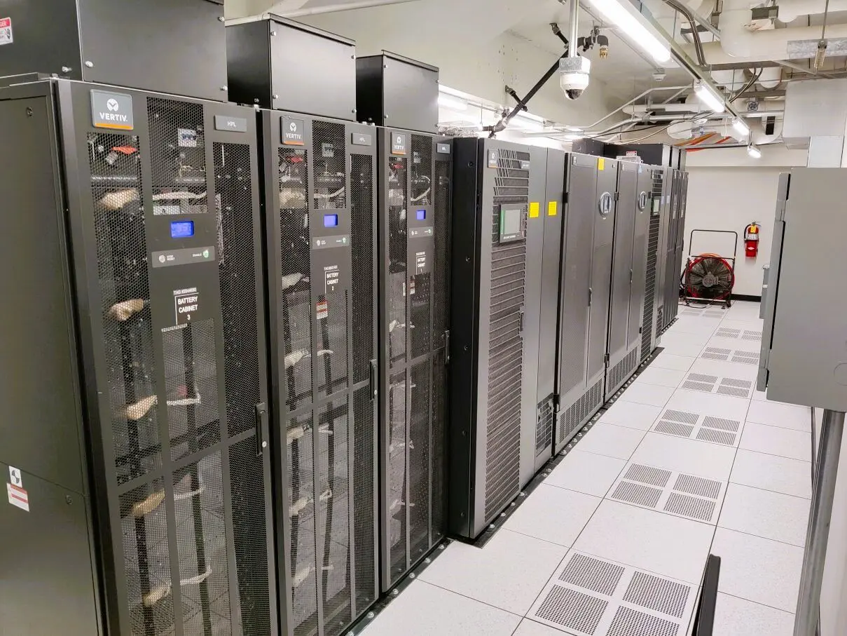 A row of servers in a room with tile floors.