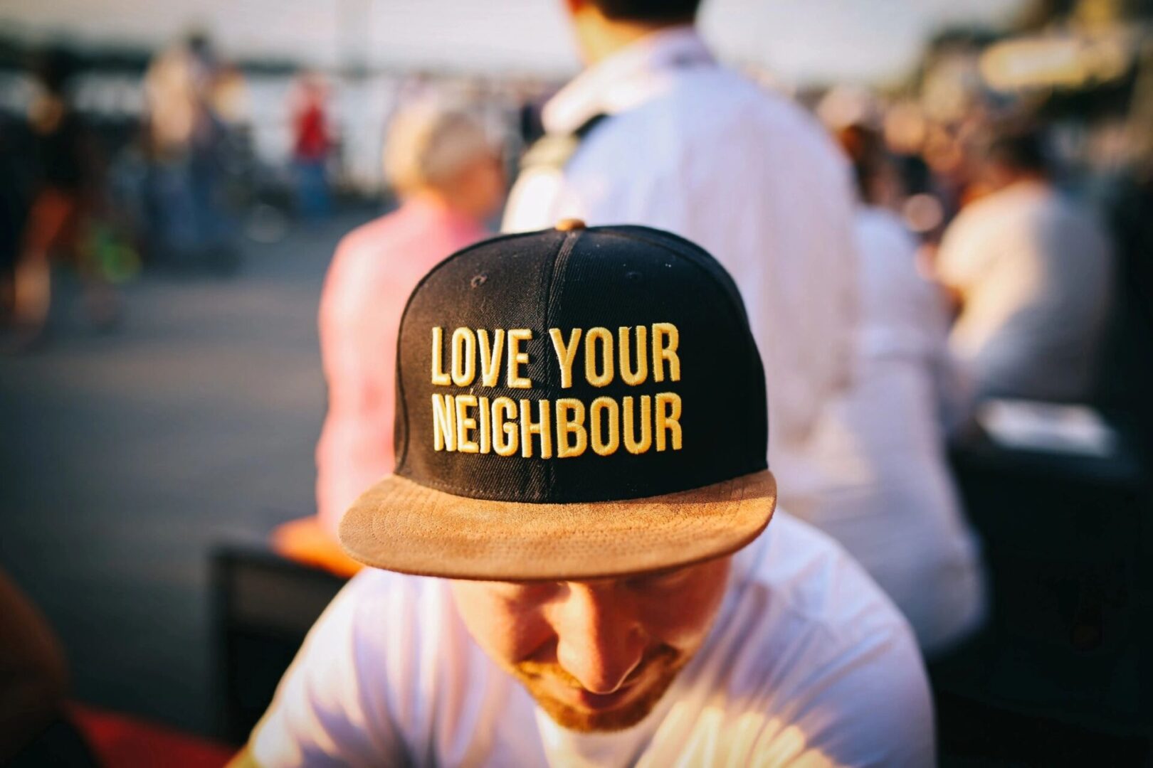 A man wearing a hat that says love your neighbour.